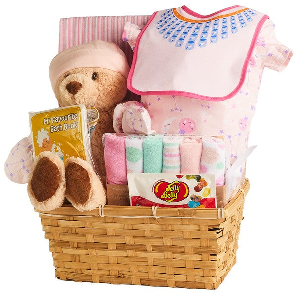 Pink baby gift basket with plush bear, baby clothes, book, sweets, and receiving blanket