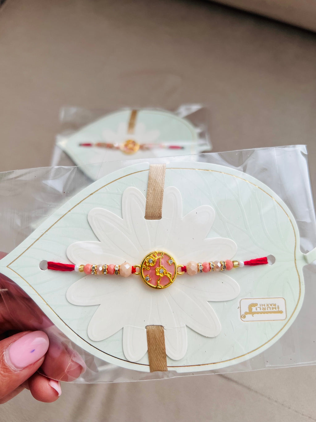 Designer Floral Rakhi – Pink Stone Centerpiece, Gold Beads & Premium Packaging