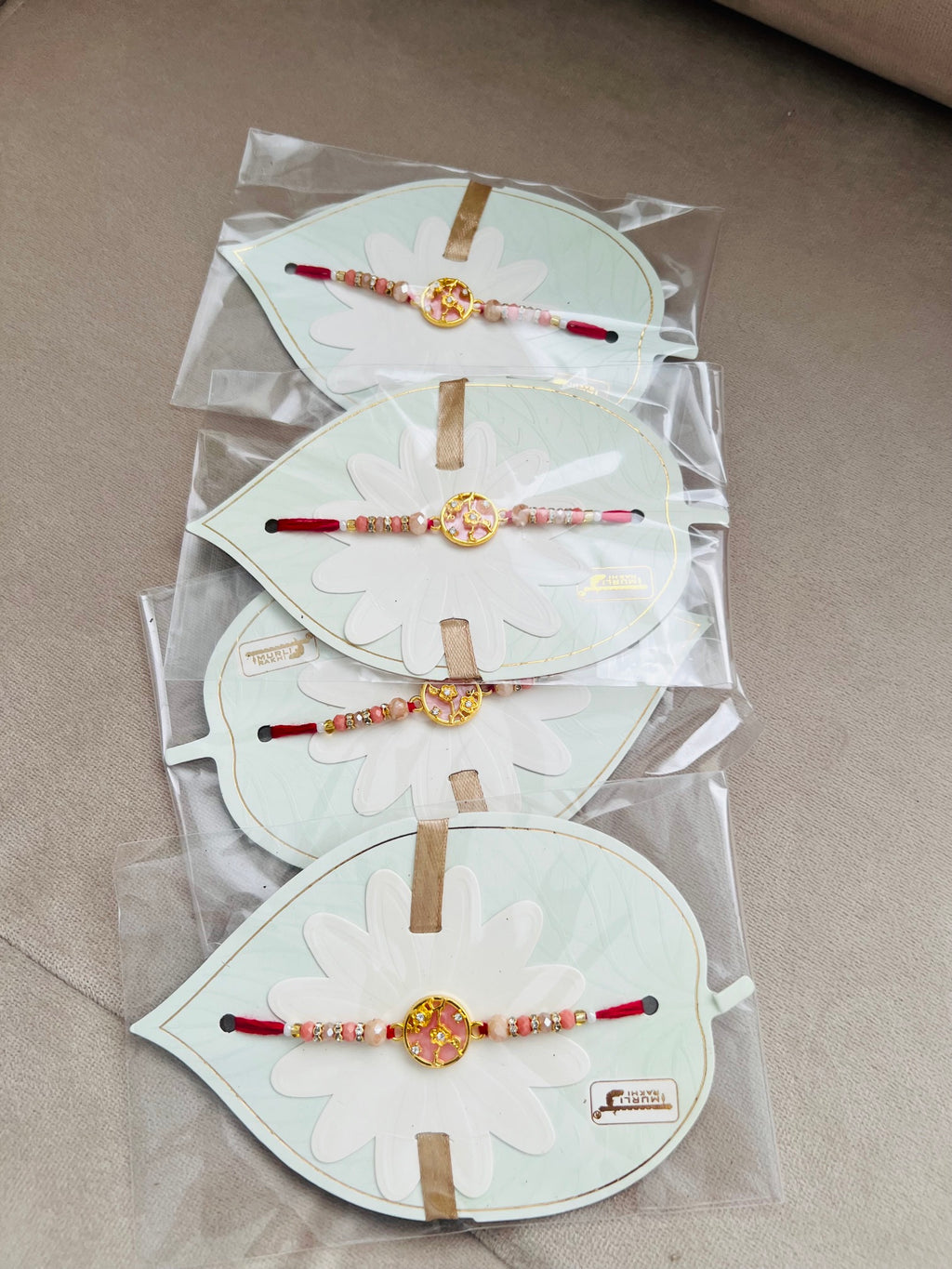 Designer Floral Rakhi – Pink Stone Centerpiece, Gold Beads & Premium Packaging