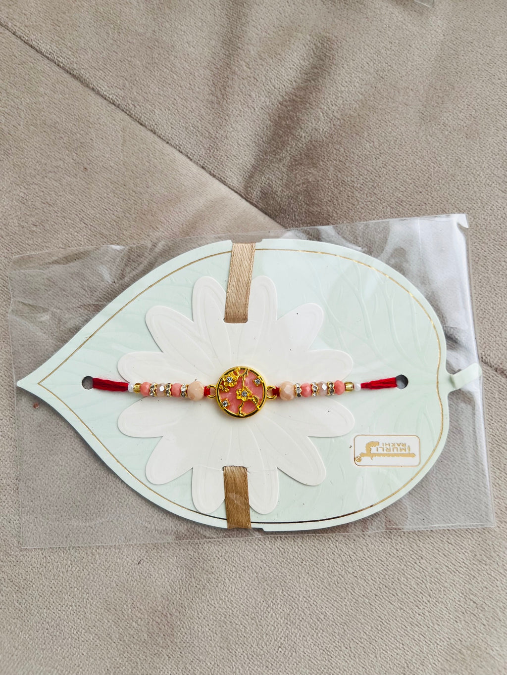 Designer Floral Rakhi – Pink Stone Centerpiece, Gold Beads & Premium Packaging