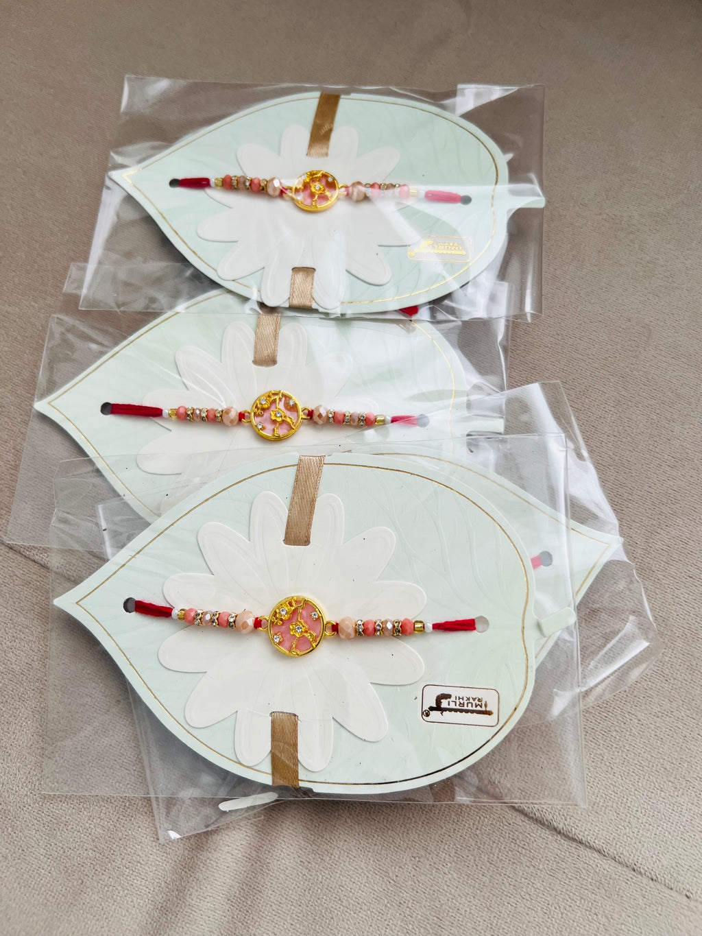Designer Floral Rakhi – Pink Stone Centerpiece, Gold Beads & Premium Packaging